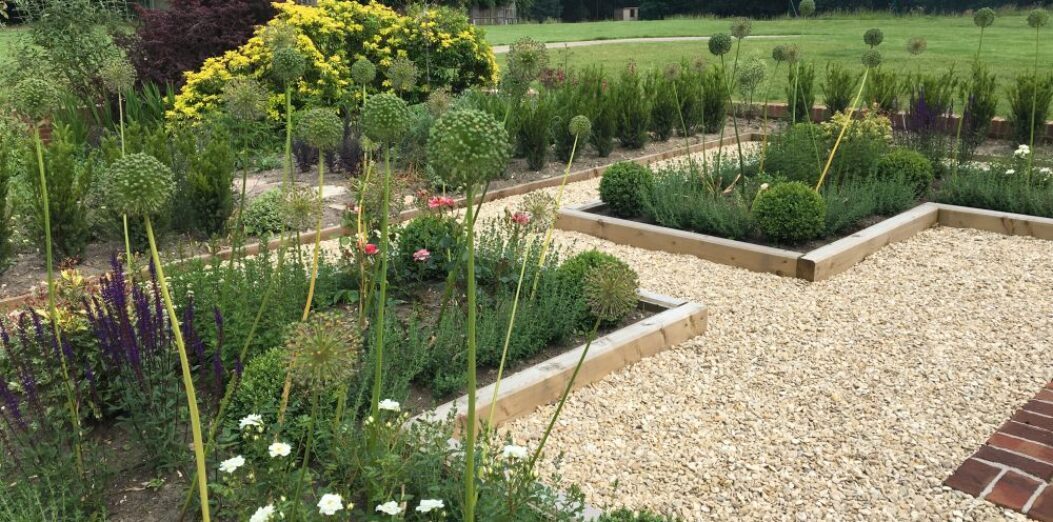 Neatly landscaped beds with gravel paths and planted borders